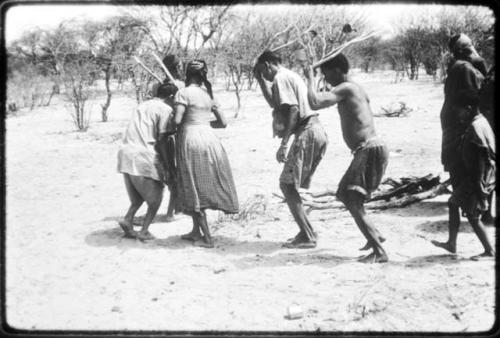 Group of people performing the Eland Dance, with Twi cutting in between ≠Kxoba and the man in front of her (copy of color slide 2001.29.8673)