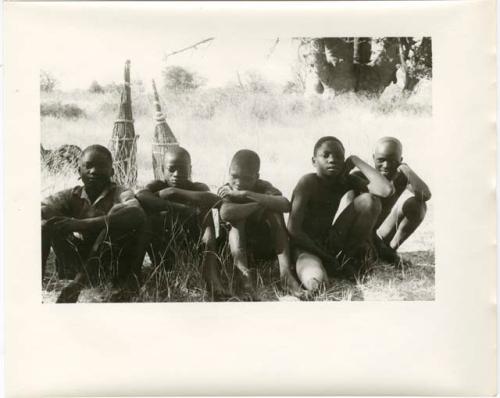 Five boys sitting near the expedition camp (print is a cropped image)