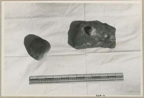 Three stones used for cracking nuts, with a ruler for measurement (print is a cropped image)