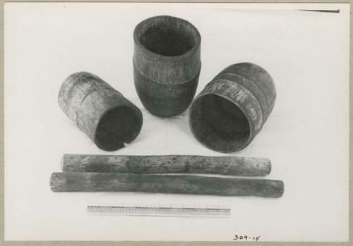 Three mortars and two pestles, with a ruler for measurement (print is a cropped image)