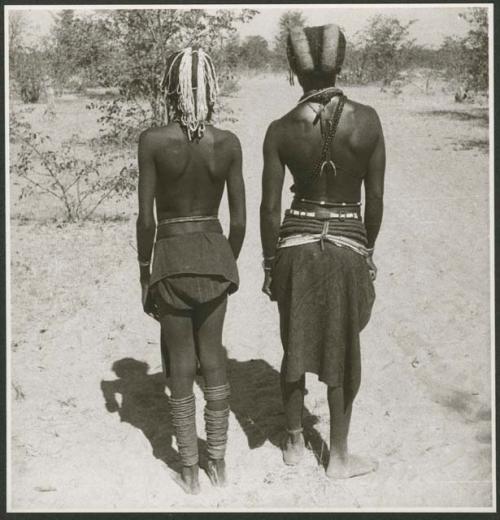 Two women standing, view of their backs