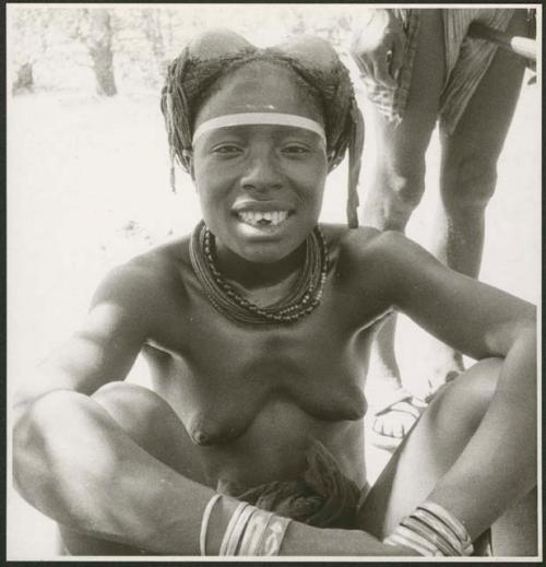 Woman sitting and showing her filed teeth