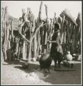 Woman stirring something in a large pottery cooking pot on the fire