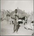 Man standing and holding a musical bow