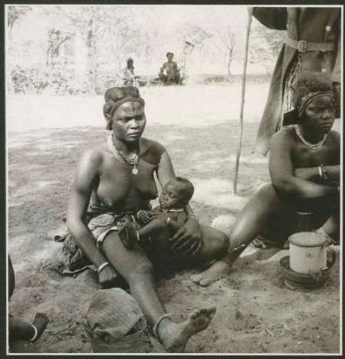 Women sitting, and one is holding a baby