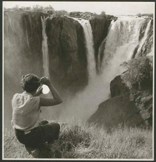 Elizabeth Marshall Thomas cutting her hair in front of the main jet of Ruacana Falls