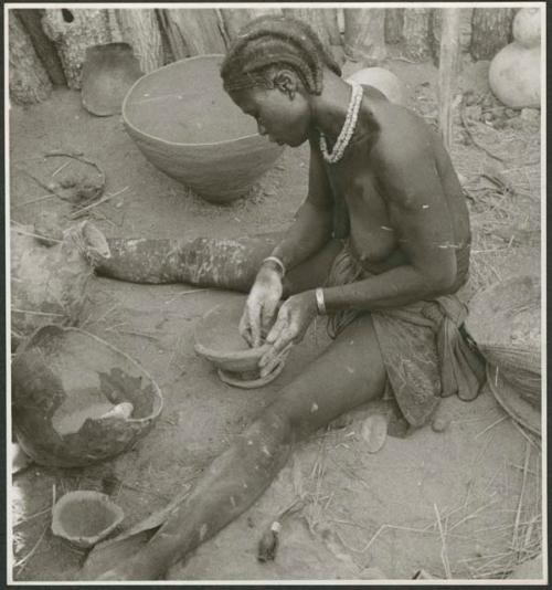 Woman sitting and making a pot