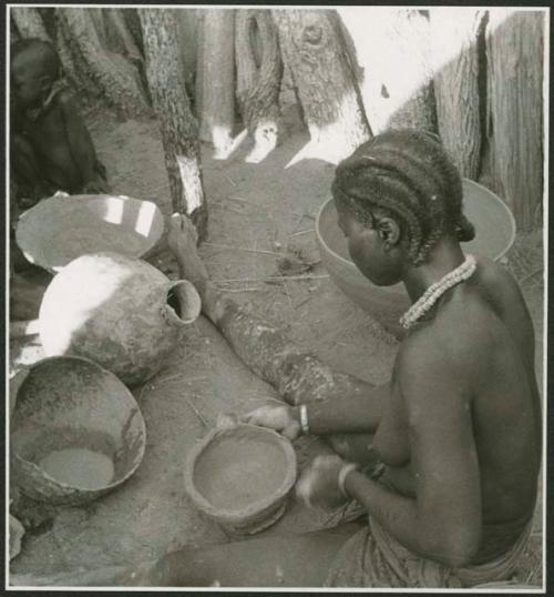 Woman sitting and making a pot