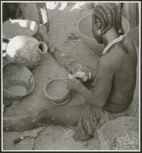 Woman sitting and making a pot