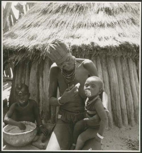 Elderly woman feeding two children