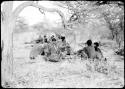 Groups of people sitting around fires where they have stopped for the night