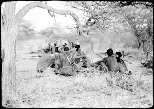 Groups of people sitting around fires where they have stopped for the night