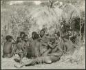 Group of Ju/'hoansi telling stories including left to right: "Lame ≠Gao" seen from behind, ≠Gao (Khwo//o-/Gasa's husband), "Gao Medicine," unidentified person seen from behind, ≠Toma, !Naishi, "Old Xama" with her hands over her head, "Gao Helmet" in profile, "Old Demi" lying down, "Crooked /Qui", Gao (Debe's son, Zuma's husband), ≠Toma (!Naishi's son), and Zuma (Gao's wife)  (print is a cropped image)