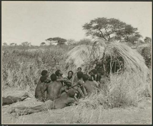 Group of Ju/'hoansi telling stories including "Lame ≠Gao," ≠Gao (Khwo//o's-/Gasa's husband), "Gao Medicine," an unidentified person, ≠Toma, !Naishi, "Old Xama," "Gao Helmet," "Old Demi" lying down, "Crooked /Qui," Gao (Debe's son, Zuma's husband), and ≠Toma (!Naishi's son) (print is a cropped image)