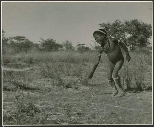 Boy pushing a toy car made from veldkos (print is a cropped image)