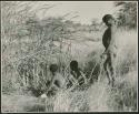 "≠Gao Lame" standing, and two unidentified boys sitting, at the edge of a waterhole (print is a cropped image)