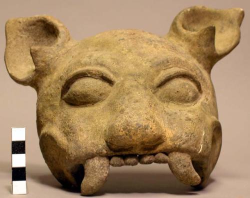 Ceramic mask of a feline, large fangs,one ear perforated, mended.