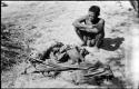 Oukwane sitting, with his possessions laid out on the ground in front of him