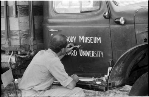 William Donnellan painting "Peabody Museum" on the expedition truck (Dodge) door