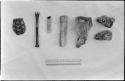 /Twikwe's possessions, including (left to right) tortoise shell spoon, three pieces of bone used for pounding and grinding, a bone dish used for mixing poison for arrows, and two pieces of ostrich bone used to give a hide a last, fine scraping, with a ruler for measurement