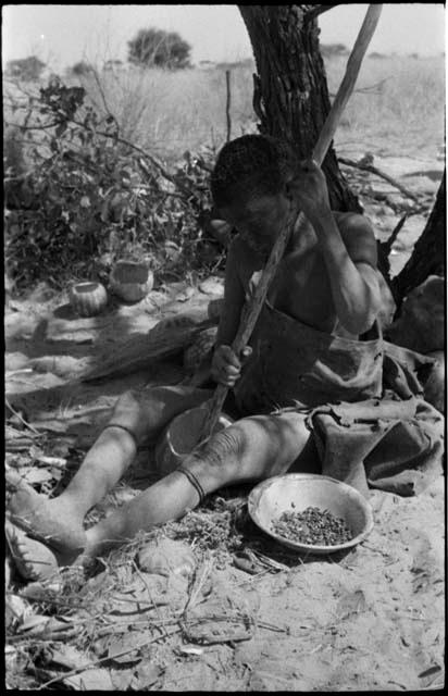 DaSi!Na sitting and removing tsama melon seeds from a melon