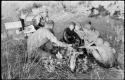 Oukwane and other people sitting and talking to William Donnellan and Elizabeth Marshall Thomas, with Wilhelm Camm interpreting. Oukwane is naming the internal parts of an animal.