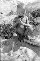 N!whakwe biting a knife, close-up