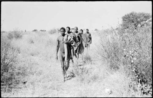 Men of a visiting band from Okwa walking in a line