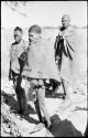 Three men, members of a visiting band from Okwa, standing