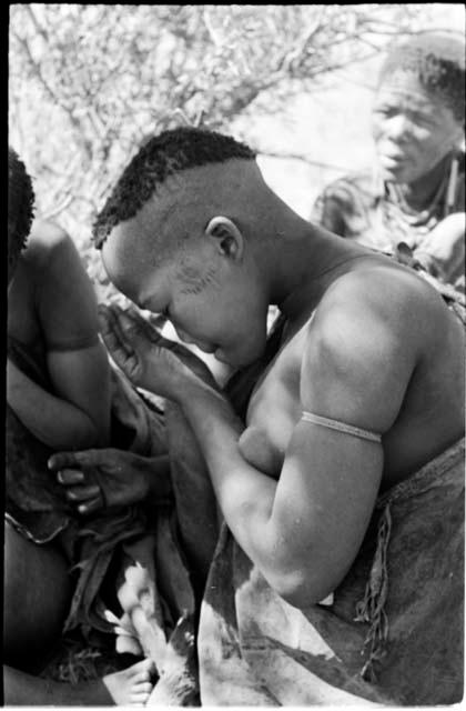 Woman visiting from Okwa, profile, close-up showing her haircut and scarification