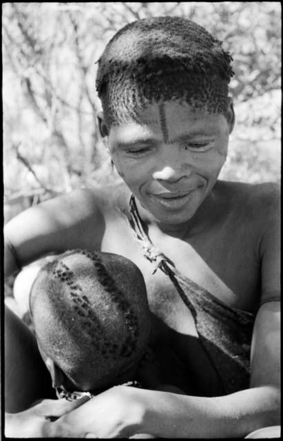 Woman visiting from Okwa, nursing her child, portrait