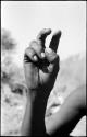 Person demonstrating the hunting hand signal for a  hartebeest, seen from the front