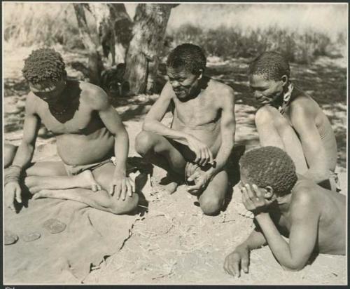 Three men sitting and looking at thrown oracle disks (print is a cropped image)