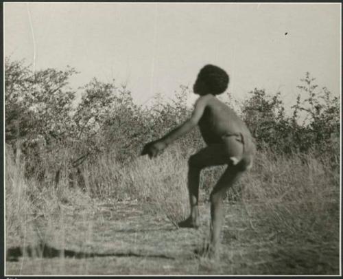 Boy tossing a djani (helicopter toy / winged toy made from a hollow reed) (print is a cropped image)