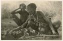 "Old /Gasa" cooking a wildebeest head, with her grandson ≠Toma (son of Gau) watching her (print is a cropped image)