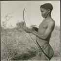 "/Qui Hunter" holding bow and arrow, showing method of holding and release (print is a cropped image)