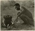 Bo, brother of /Naoka (first wife of "Gao Medicine"), visiting Gautscha, and cooking meat in an Ovambo pot (print is a cropped image)