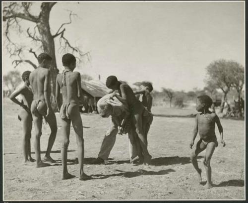 Group of boys playing with John Marshall, including /Gishay (son of "Old Gau"), ≠Toma (son of Gau), !Naishi, and //Ao (son of "Old ≠Toma" of Band 2) (print is a cropped image)