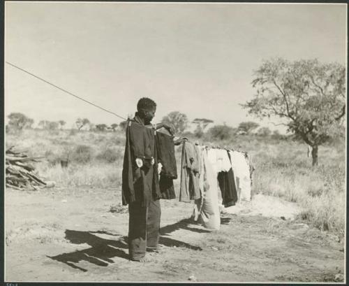 Member of expedition staff hanging clothes (print is a cropped image)