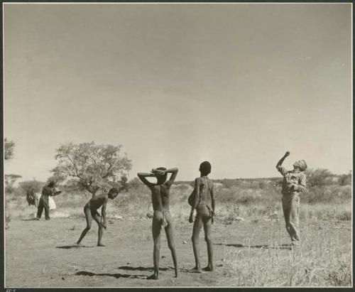 Boys playing a game with John Marshall in camp (print is a cropped image)