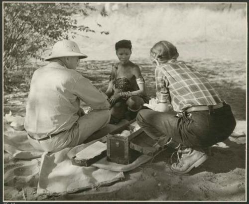 /Naoka holding her daughter /Khoa ("/Qui Hunter's" daughter) and sitting with Laurence Marshall and Lorna Marshall (print is a cropped image)