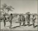 Boys and girls dancing, with a girl playing the //guashi; "Little N!ai" is standing fourth from the left (print is a cropped image)