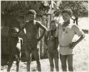 Boys standing beside the Okwa hut with wall drawings (print is a cropped image)