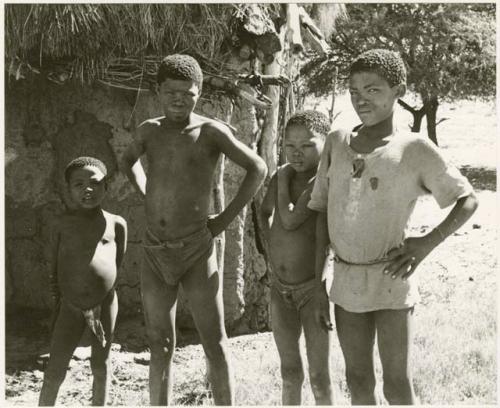 Boys standing beside the Okwa hut with wall drawings (print is a cropped image)