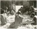 Group of men hulling corn (print is a cropped image)