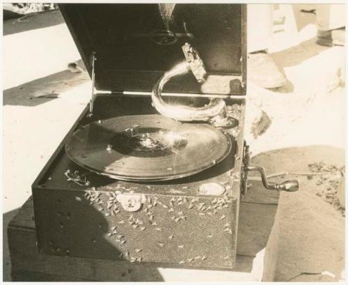 Boys' phonograph open, sitting on a crate (print is a cropped image)