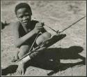 /Gishay, son of "Old Gau," squatting and holding a quiver and bow (print is a cropped image)