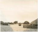 Truck driving through a local village (print is a cropped image)