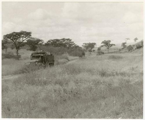 Truck driving in the riverbed (print is a cropped image)