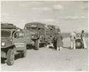 Expedition members changing the tire of the GMC truck (print is a cropped image)